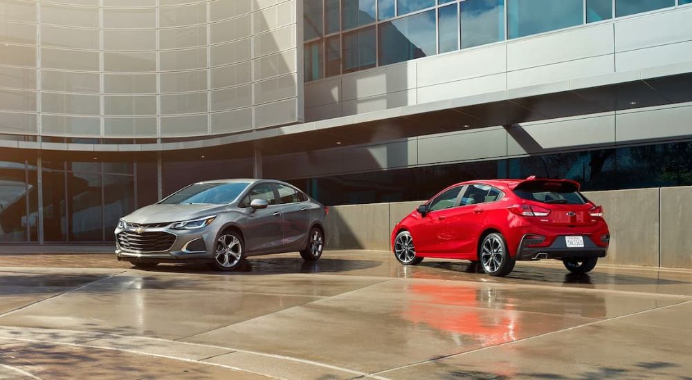 A silver and red used 2019 Chevy Cruze parked outside a building