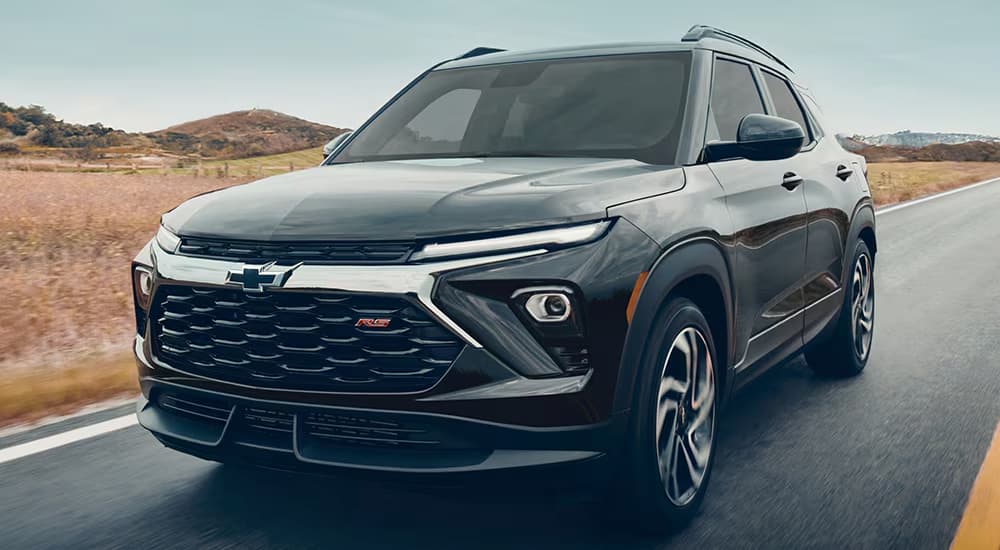 A black 2026 Chevy Trailblazer driving down a road