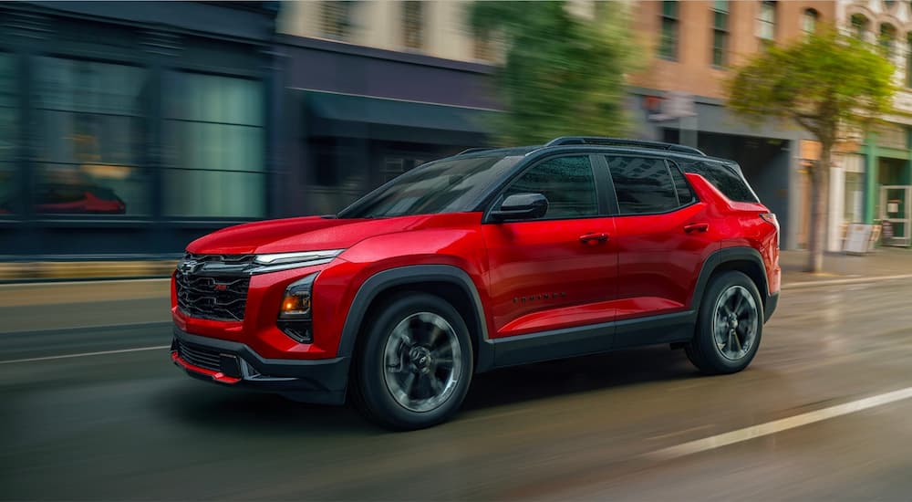 Red 2026 Chevy Equinox RS driving down a road.