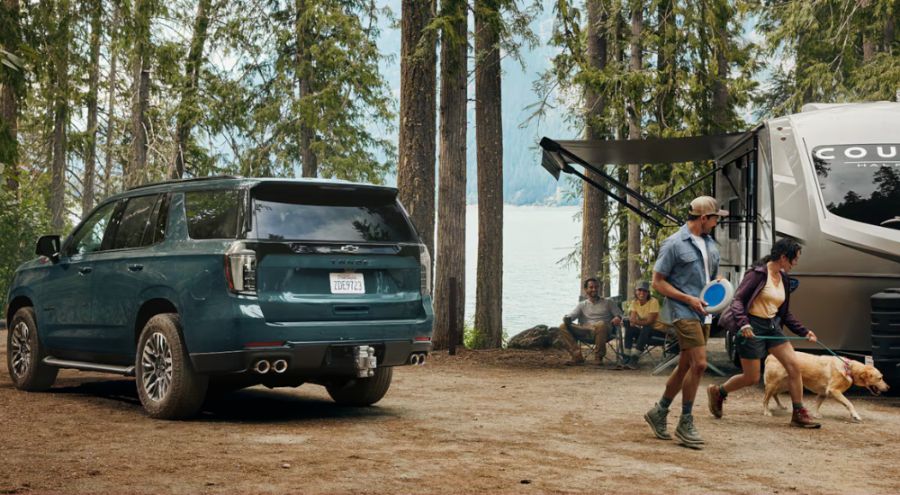 Green 2026 Chevy Tahoe from the rear on a campsite.
