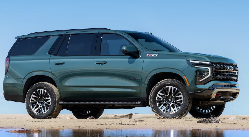 Side of a green 2026 Chevy Tahoe parked off-road.