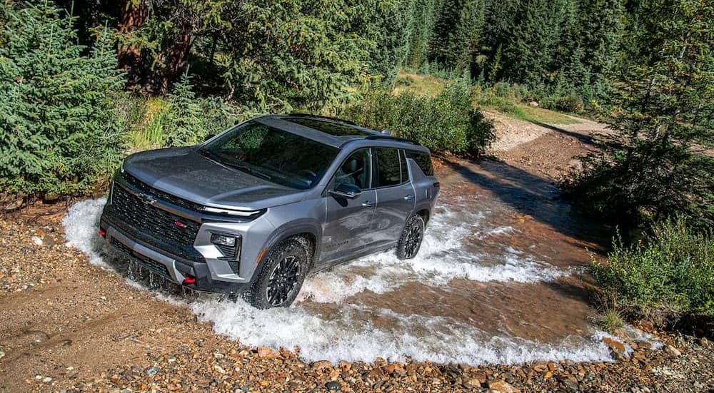 A silver 2026 Chevy Traverse Z71 driving through water.