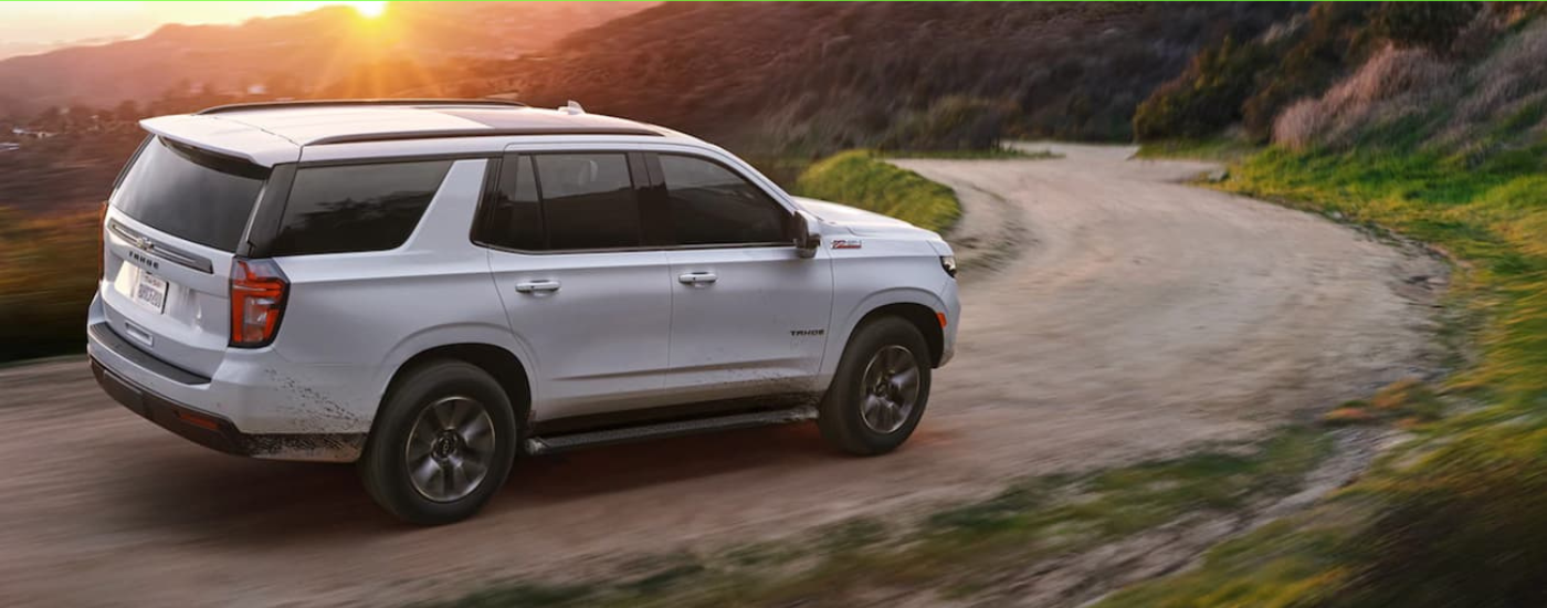 White 2021 Chevy Tahoe driving down a mountain trail