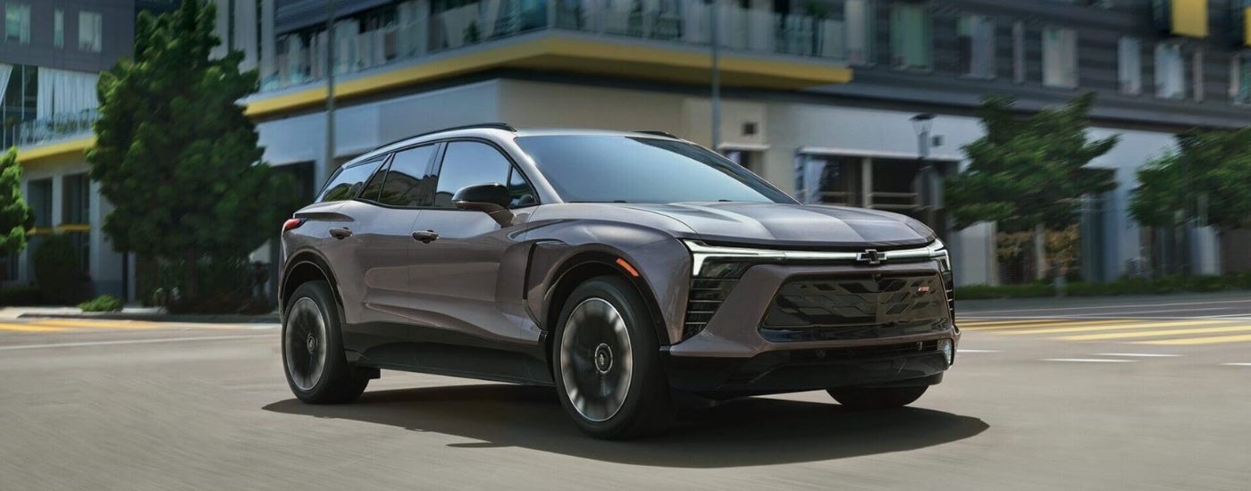 Silver 2025 Chevy Blazer EV driving through a city