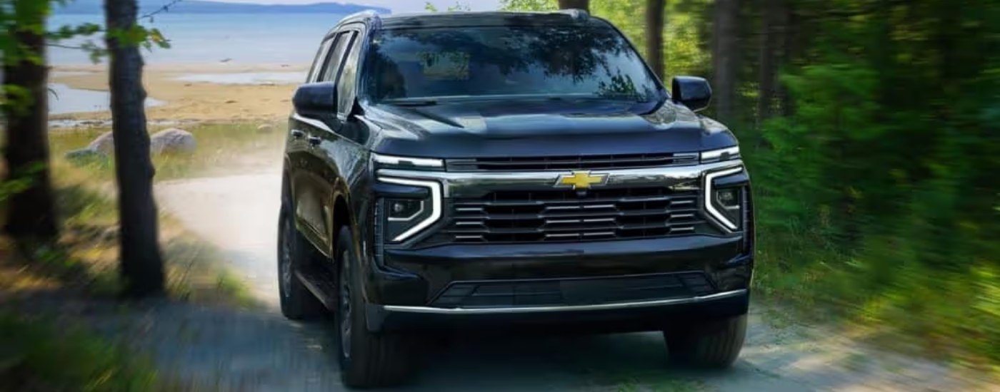 Black 2026 Chevy Tahoe driving away from a beach head on