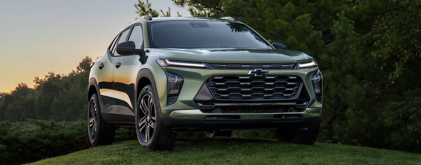A green 2025 Chevy Trax ACTIV parked off-road on grass