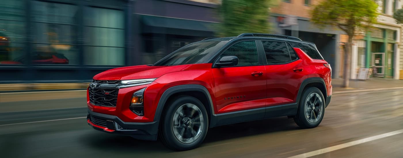 Red 2026 Chevy Equinox driving down an open road.