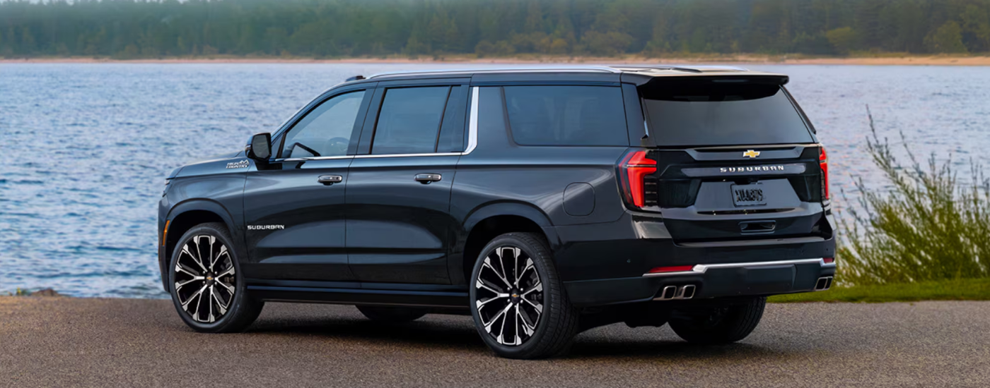 Black 2026 Chevy Suburban parked by a lake