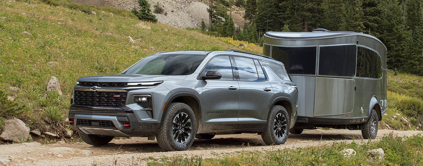Grey 2026 Chevy Traverse towing a trailer off-road.