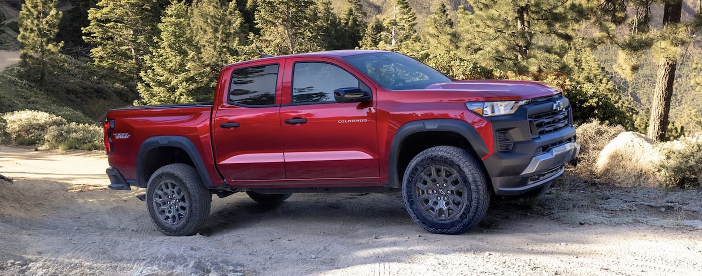 Red 2023 Chevy Colorado Trail Boss parked on a dirt trail.