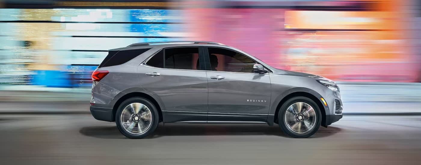 A silver 2025 Chevy Equinox driving in a city.