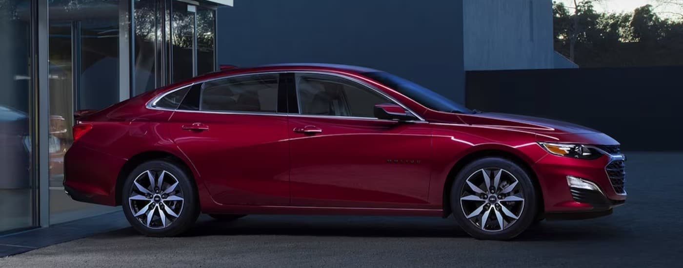 A red 2024 Chevy Malibu parker on a driveway.
